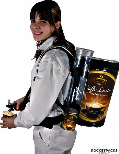 Promoterin mit isoliertem Kaffeerucksack und Café-Latte-Werbung beim mobilen Ausschank von Kaffee.
